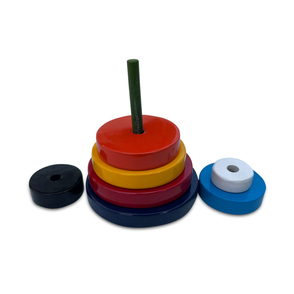 Round stacking rings in red, yellow, blue, black and white beside the peg