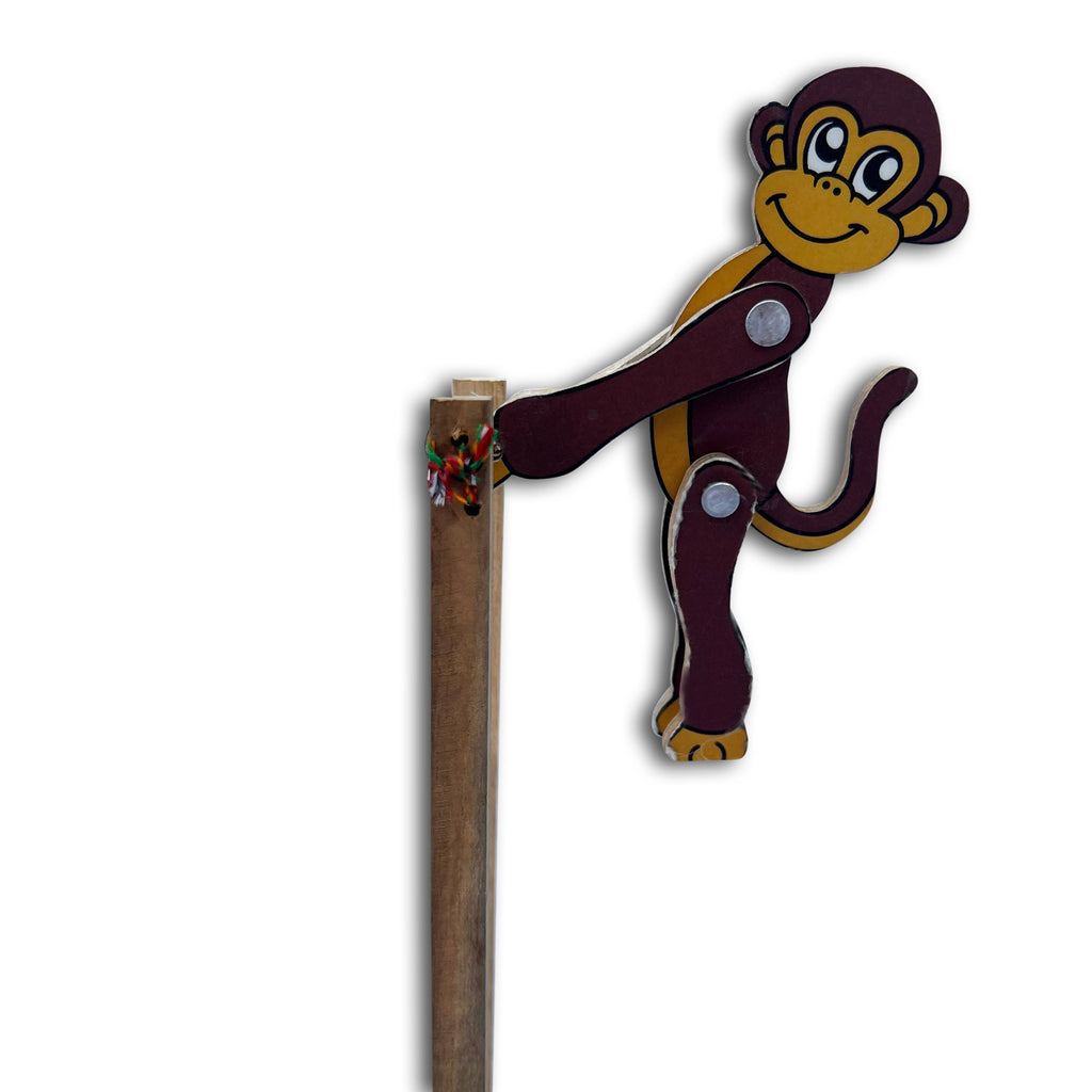 Wooden jumping monkey toy hanging over the top of its sticks
