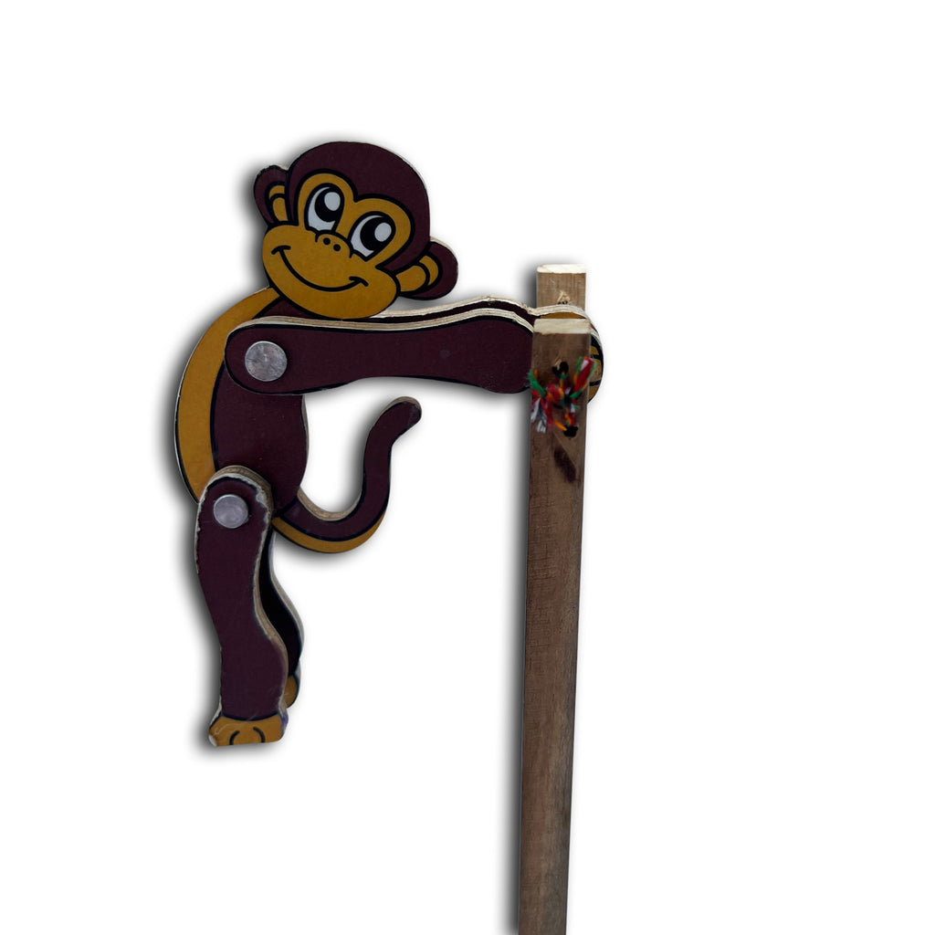 Jumping monkey toy mid-flip between two wooden sticks