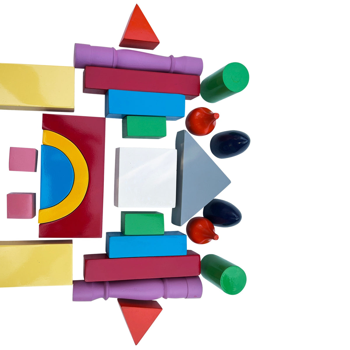 Colourful wooden building blocks laid out: arches, cylinders, cubes and triangles